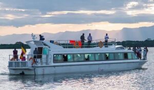 Tour boat cruising on Lake Victoria near Entebbe, Uganda, with scenic open water and sunset views
